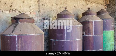 Rostige gebrauchte Olivenölfässer. Alte Farm Stockfoto