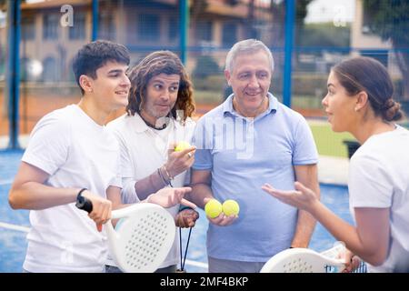 Zwei Padel-Spieler diskutieren auf einem offenen Platz glücklich über das vergangene Spiel Stockfoto