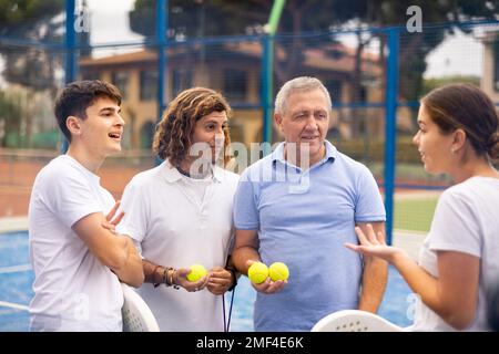 Zwei Padel-Spieler diskutieren auf einem offenen Platz glücklich über das vergangene Spiel Stockfoto