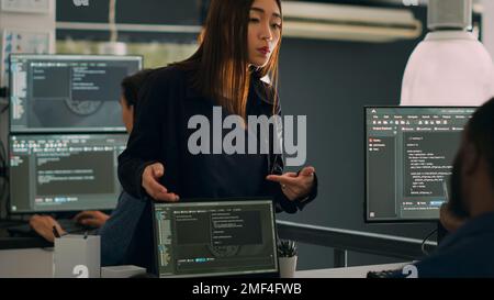 Programmierer arbeiten an einem Gruppenprojekt zusammen und sprechen über den Codierungsalgorithmus für die neue Cloud-Computing-Benutzeroberfläche. Unterschiedliches Team von Software-Ingenieuren, die den Systemcode der Datenbank ausführen. Stockfoto