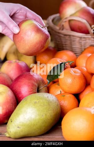Mischung aus frischem Obst. Äpfel, Orangen, Mandarinen, Bananen und Birnen auf dem Tablett. Stockfoto
