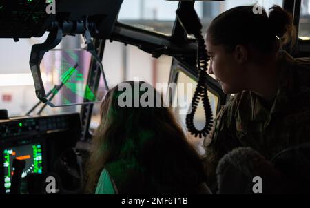 USA Air Force Senior Airman Anibel MacRae, 86. Aircraft Maintenance Squadron Aircraft Maintenance Unit Crew Chief, rechts, zeigt Genevieve Paradis, der Teil einer Ramstein Area Girl Scout Truppe ist, das Cockpit eines 86. Airlift Wing C-130J Super Hercules Flugzeugs auf dem Luftwaffenstützpunkt Ramstein, Deutschland, 17. August 2022. MacRae demonstrierte das Heads-up-Display, das dem Piloten und Kopiloten während des Fluges Flugdaten liefert. Stockfoto