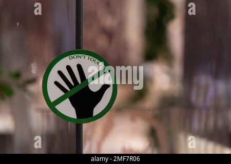 Nahaufnahme des „Don't Touch“-Schilds auf dem Glas. Stockfoto