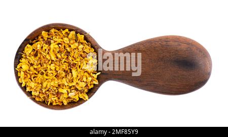 Osmanthus-Tee im Holzlöffel, isoliert auf weißem Hintergrund. Trockene Blüten von Osmanthus-Duftstoffen. Draufsicht Stockfoto