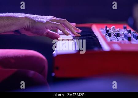 Die Hände eines Musikers spielen eine elektronische Tastatur, Synthesizer, auf einer Konzertbühne. Sehr geringe Schärfentiefe. Stockfoto
