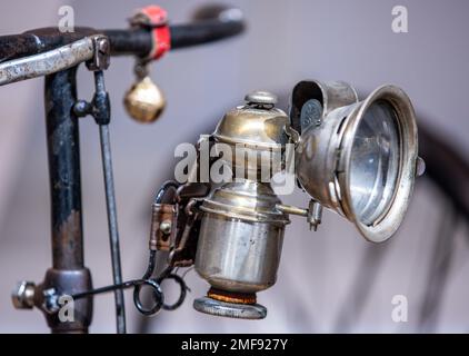 Wismar, Deutschland. 24. Januar 2023. Eine Hartmetalllampe hängt an einem der historischen Fahrräder in der neuen Dauerausstellung von mehr als 50 historischen Fahrrädern im Phantechnikum. Das seltene Fahrrad war seit Jahrzehnten verloren und wurde erst vor ein paar Jahren im Garten eines Modehauses wieder aufgetaucht. Das Technologiemuseum wird am 25. Januar 2023 als Erweiterung seiner Dauerausstellung einen Schwerpunkt auf die technische und kulturelle Geschichte des Fahrrads legen. Die Fahrräder aus der Sammlung eines Sammlers aus Wismar veranschaulichen Meilensteine der Fahrradgenese und verbinden sie mit wi Credit: dpa/Alamy Live News Stockfoto