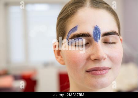 Junge Frau im Augenbrauenkorrekturverfahren mit Wachs. Stockfoto