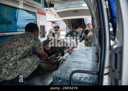 USA Air Force und Personal der Royal Malaysian Air Force laden einen simulierten Patienten in einen Krankenwagen während eines Massenunfalls und flugmedizinischen Evakuierungsszenarios zur Unterstützung der Übung Pacific Angel auf dem Luftwaffenstützpunkt Kuantan, Malaysia, 18. August 2022. Pacific Angel war eine einwöchige multilaterale Übung, bei der 370 Teilnehmer aus sechs Ländern zusammenkamen, um die Zusammenarbeit und Interoperabilität bei humanitären Hilfseinsätzen und Katastrophenhilfemaßnahmen zu fördern. Stockfoto