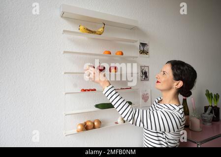 16. Januar 2023, Hessen, Frankfurt/Main: Sabine Nietmann in der Küche ihrer Wohnung in Frankfurt. Neben ihrer Tätigkeit als Flugbegleiterin arbeitet die 35-jährige als Aufräumlehrerin und hilft ihren Kunden, Ordnung in ihrem persönlichen Wohnumfeld zu schaffen. (Zum dpa „Order Coach helps in Daily life“ von 25.01.2023) Foto: Boris Roessler/dpa Stockfoto