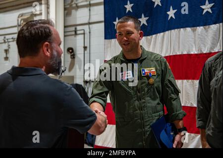 Cmdr. James Conner, ein MH-65 Dolphin Helikopter-Pilot, wird beglückwünscht, nachdem er während einer Preisverleihung in der Coast Guard Air Station Houston, Texas, am 19. August 2022 eine Medaille der Coast Guard Air erhalten hat. Während der Zeremonie überreichte Konteradmiral Richard V. Timme, Commander, Coast Guard District Acht, Conner die Luftmedaille für seine Rolle bei der Rettung von neun festsitzenden Besatzungsmitgliedern aus dem Pride Wisconsin, einer stillgelegten mobilen Offshore-Bohreinheit, die am 24. Februar 2022 in Sabine Pass, Texas, Feuer fing. Stockfoto