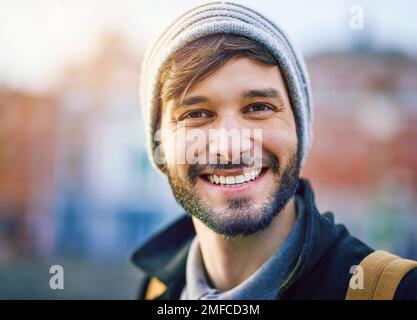 Sein Lächeln sagt viel darüber aus, wer er ist. Porträt eines selbstbewussten jungen Mannes in der Stadt. Stockfoto