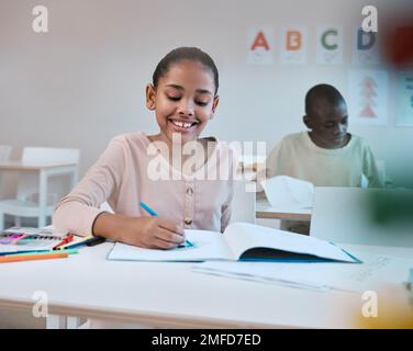 Erziehung, Lächeln und Kind im Klassenzimmer lernt Lesen, Schreiben und Mathematik an der Montessori-Schule in New York. Bücher, Schüler und glückliches Mädchen im Kind Stockfoto