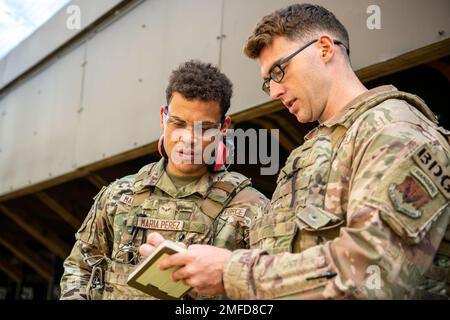 Ein Ausbilder der 820. Base Defense Group, rechts, spricht mit Airman 1. Klasse Richard Maria Perez, 423d Sicherheitsgeschwader, während eines Kompetenzkurses an der RAF Molesworth, England, am 19. August 2022. Während des Kurses gaben Ausbilder der 820. Base Defense Group und der 435. Contingency Response Group Aufsicht und Anleitung, um die Kampfwaffenkenntnisse der Verteidiger der 423d SFS zu kritisieren und zu verbessern. Stockfoto