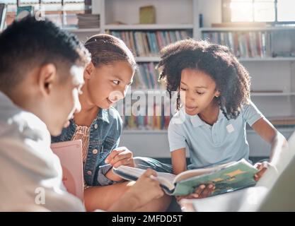 Bildung, Geschichtenerzählen oder Schüler, die in einer Bibliothek lesen, um sich in der Gruppe weiterzuentwickeln oder weiterzuentwickeln. Vielfalt, Kinder oder Kinder, die reden oder sprechen Stockfoto