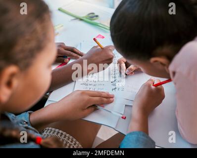 Schule, Kinder und Hände schreiben für Lernaktivität im Gruppenunterricht zusammen mit Draufsicht. Kleine Kinder und Schüler, die sich mit Alphabetisierung beschäftigen und Stockfoto