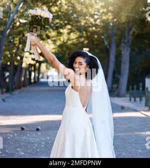 Braut, Hochzeit und schwarze Frau mit Blumen im Park draußen. Porträt, Heirat oder Schönheit einer glücklichen Frau, die einen Blumenstrauß von Rosen hochhält Stockfoto