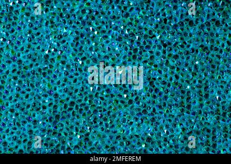 Abstrakter Strasssteinhintergrund. Textur der Strasssteine, die mit blauem Licht beleuchtet werden. Rosa und blaue glänzende Diamanten. Schließen. Leuchtfackeln auf Glas. Stockfoto