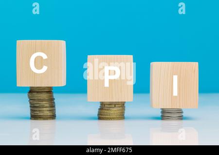 CPI – Wortsymbol für Kundenpreisindex – Geschäftskonzept. Holzblöcke mit Buchstaben CPI auf gestapelten, aufsteigenden Münzen. Stockfoto