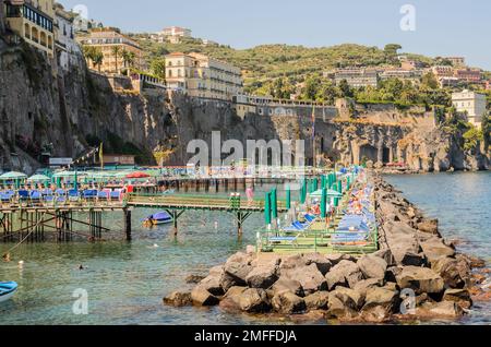 Ein gefertigter Anlegesteg Sorrent Italien mit großen Felsen und Felsen und hinter den Klippen mit Hotels Stockfoto