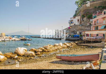 Sorrent Italien August 1 2013 kleine Marina mit Booten, Hafenmauern und Restaurant und Vesuv im Hintergrund Stockfoto