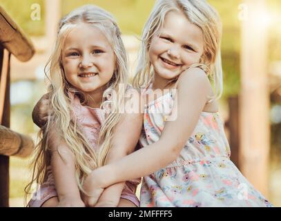 Fröhliches, lächelndes Mädchen und Teddy-Porträt im Freien mit Glück, Schwestern und Verbundenheit. Freiheit, Kinder und Lächeln kleiner Kinder mit Freund Stockfoto