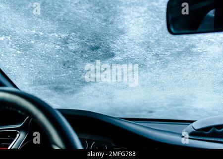 Gefrorene Windschutzscheibe mit Eis und Schnee an einem Wintertag. Selektiver Fokus. Stockfoto