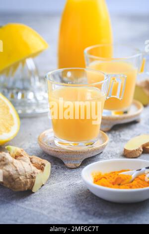 Hausgemachte Kurkuma Zitrone Ingwer Shots in kleinen Gläsern, gesunde Ingwer Zitrone Kurkuma Shot – ideal, um das Immunsystem im Winter zu stärken Stockfoto