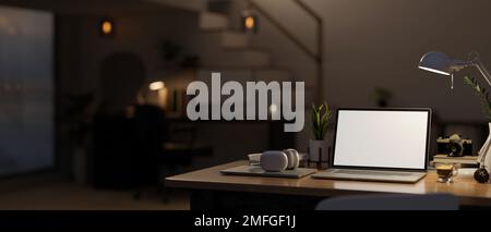 Moderner Arbeitsplatz in Ihrem Zuhause bei Nacht mit weißem Laptop-Mockup, Licht von Tischleuchte, Kopfhörer und Zubehör auf dem Tisch über verschwommenem Hintergrund von D. Stockfoto