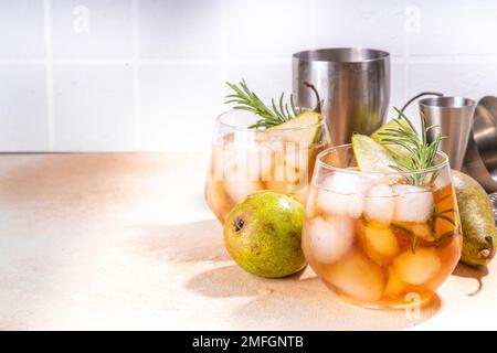 Alkohol fruchtiges Getränk, süßer kalter Birnencocktail mit Rum, Likör, Aniswein und Rosmarin-Zweig, garniert mit Birne in Scheiben geschnitten Stockfoto