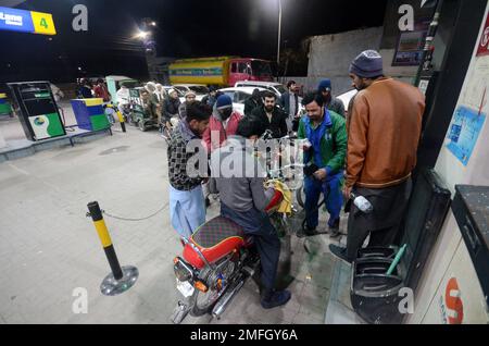 Peshawar, Khyber Pakhtunkhwa, Pakistan. 23. Januar 2023. Die Leute warten einen Tag nach einem landesweiten Stromausfall, bis sie an einer Tankstelle tanken. Am Montag wurden lange Schlangen an Autos und Motorrädern an Tankstellen in den meisten Teilen von Khyber Pakhtunkhwa, einschließlich der Hauptstadt, beobachtet, nachdem die Öllieferungen von Ölvermarktungsunternehmen zurückgegangen waren. Nach der Benzinkrise gibt es lange Schlangen an den Tankstellen auf der G.T Road. Ein Großteil Pakistans blieb am Montag ohne Strom, da die Regierung als Energiesparmaßnahme nach hinten losging. Der Ausfall verbreitete Panik Stockfoto