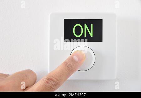 Digitaler Thermostat mit Fingerdruck auf die Taste ON Start Stockfoto