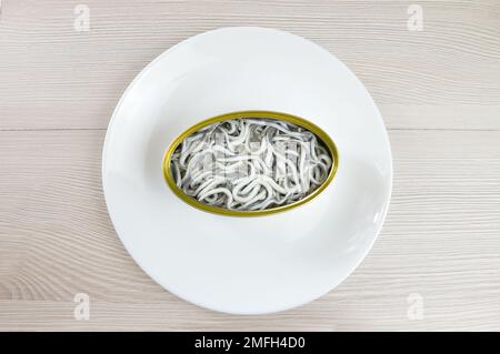 Aus einem hohen Winkel, mit einer köstlichen Dose Aal auf einem rustikalen Holztisch Stockfoto