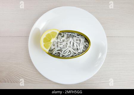 Dose mit Aalen mit Zitrone auf einem rustikalen Holztisch Stockfoto