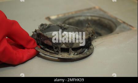 Reinigung des Abflusses. Verstopfte und verschmutzte Abflussrohre. Voller Haare und angestautes, verstopftes Fett. Wartung der Bodenabflussanlage in b Stockfoto