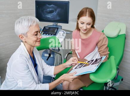 Frau sitzt auf dem gynäkologischen Stuhl während der Beratung mit ihrem Gynäkologen in der gynäkologischen Praxis der medizinischen Klinik. Frauengesundheit, Gynäkologie Stockfoto