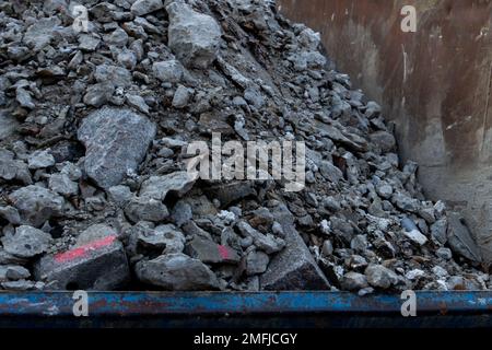 Nahaufnahme von Betonabfällen in einem Stahlbehälter Stockfoto