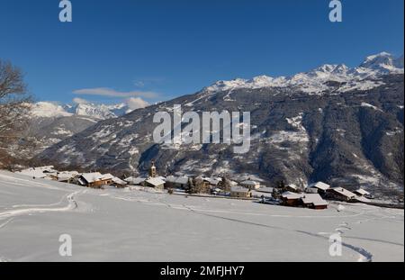 alpendorf im tarentaise-Tal mit Blick auf schneebedeckte Berge unter blauem Himmel Stockfoto