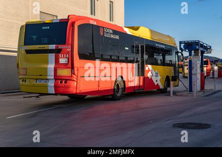 Felanitx, Spanien; januar 21 2023: Bus des öffentlichen Verkehrsunternehmens TIB, der in einem Industriegebäude in der Dämmerung geparkt ist. Erdgasbus. Felanitx, Insel Stockfoto