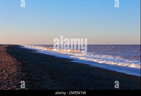 Ein Blick auf den Strand am Niedrigwasser in North Norfolk mit Blick nach Westen in Richtung Blakeney Point bei Cley Next the Sea, Norfolk, England, Großbritannien. Stockfoto