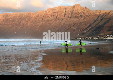 Surfer am Strand von Caleta de Famara, Playa de Famara, Lanzarote. Stockfoto