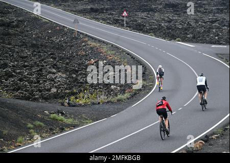 Radfahrer auf der Straße durch den Timanfaya-Nationalpark auf Lanzarote. Stockfoto