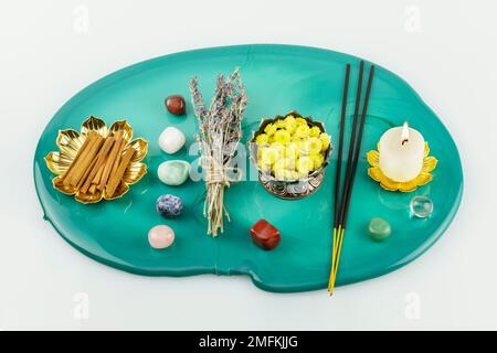 Selbstpflege, heilende Komposition mit Kerzen, Aromastifte, Chakrasteine, Sandelholzstangen und trockenen Blumen auf grünem Marmorpodium. Konzept der Entspannung Stockfoto