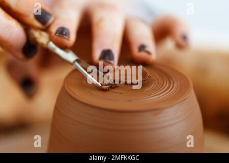 Weibliche Hände halten eine Schüssel zum Gießen von Tonprodukten. Formmethode zur Herstellung von Tonschalen. Handarbeit. Töpferei. Nahaufnahme. Töpferrad Stockfoto