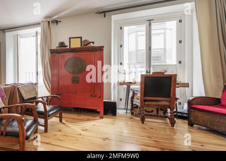 Wohnzimmer mit eklektischer Dekoration mit alten Holzmöbeln auf hochwertigen Kiefernholzböden Stockfoto