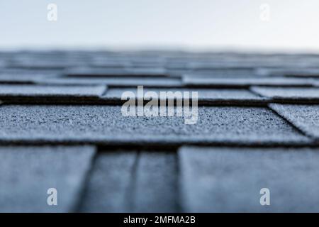 Mattratdach mit Bitumenschindeln. Der Beginn des Winters. Stockfoto