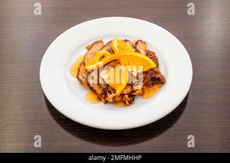 Typisches Rezept eines chinesischen Restaurants in Europa, basierend auf gerösteter Ente mit Orangen auf einem weißen Teller Stockfoto