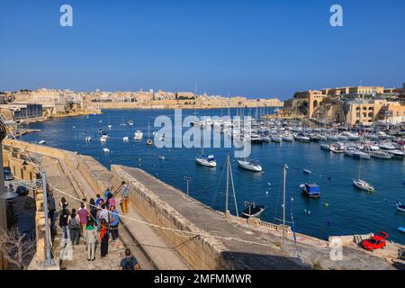 Birgu, Malta - 11. Oktober 2019 - Gruppe von Touristen in Birgu (Vittoriosa) an der Kalkara Marina im Grand Harbour mit Blick auf die Stadt Valletta. Stockfoto