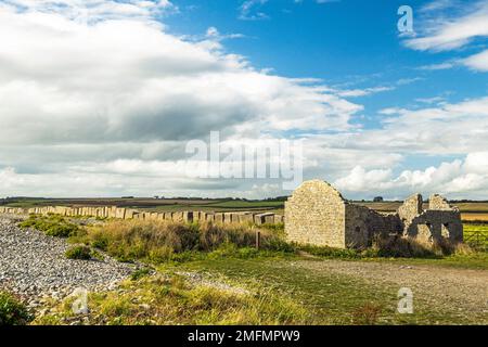 Limpert Bay mit einem verlassenen alten Haus und Panzerabwehrblöcken in Aberthaw an der Südwales Küste Stockfoto