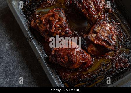 Grillrippchen auf einem Backblech, isoliert auf dunklem Hintergrund. Draufsicht Stockfoto