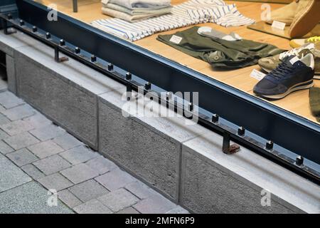 Feindselige Architektur, defensiver Frontshop mit Metallarmlehnen, die verhindern sollen, dass Leute sich an der Fassade des Ladens hinlegen Stockfoto